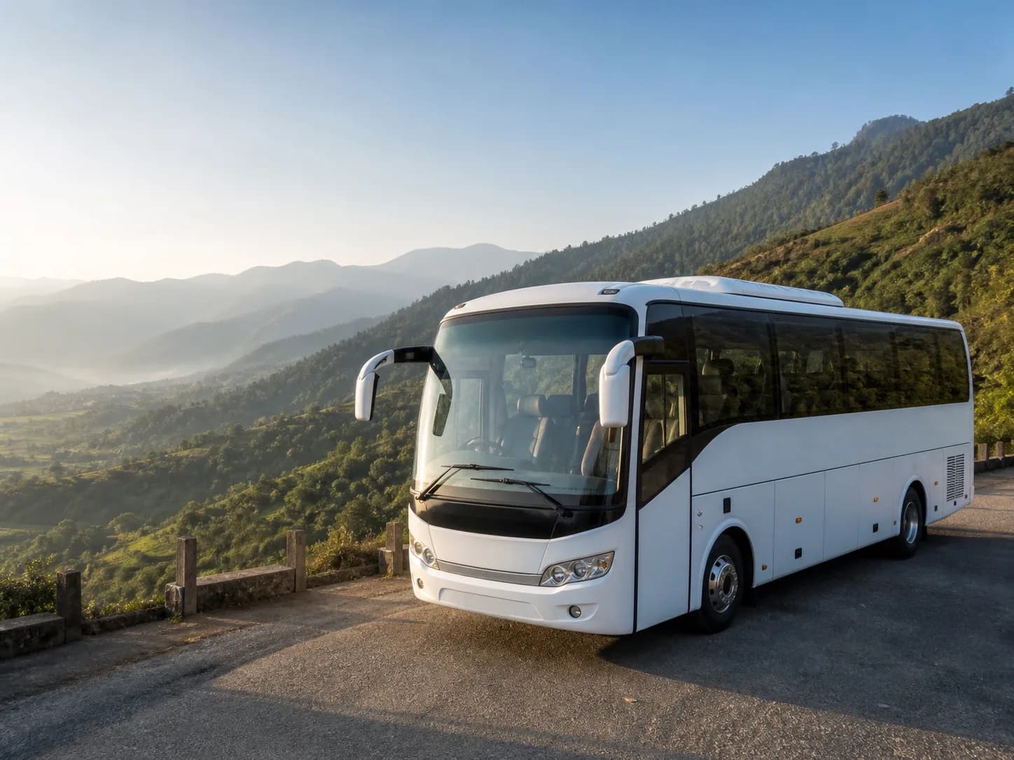 A modern white tourist coach overlooking a green valley